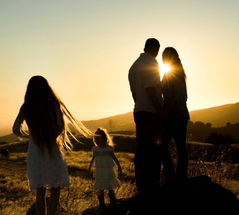 Perhe katsomassa auringonlaskua