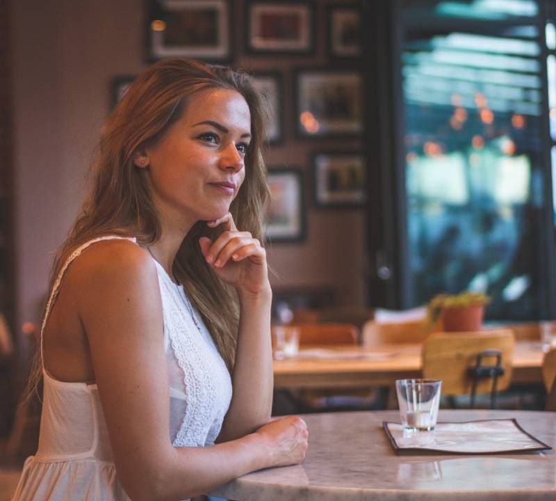 אישה יושבת בבית הקפה