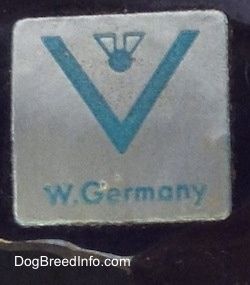 Tutup - Di bahagian bawah patung terdapat sekerat dan pelekat biru yang mempunyai lebah penuh di dalam logo V dan di bawahnya terdapat kata-kata - W.Jerman.
